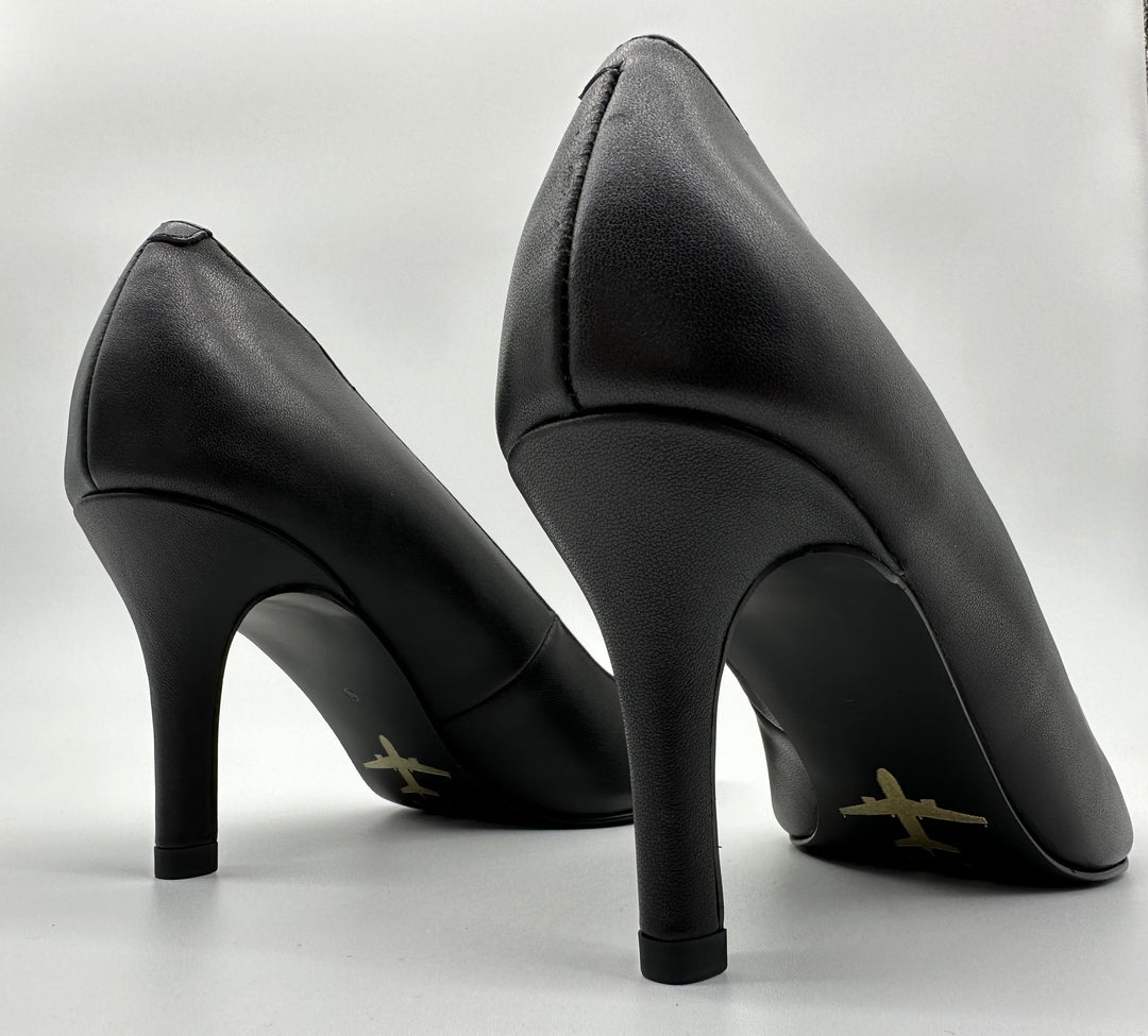 Classic black pump with a golden airplane image stamped against black outsole.